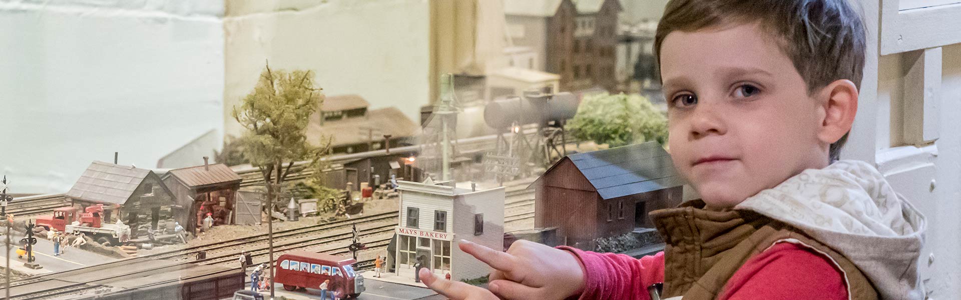 Little boy pointing on toy trains