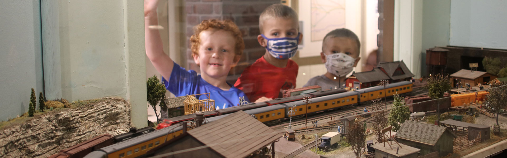 3 little boys watching model trains