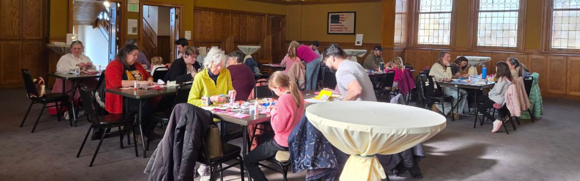 people in museum auditorium participating in craft activity